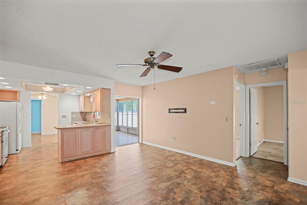 An open-concept living area features a kitchen with light wood cabinets and tile flooring — 1112 40TH AVE NE, ST PETERSBURG, FL