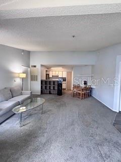 A living room with gray carpet and a sofa leads to an open dining area — 2212 GRAND CAYMAN COURT UNIT 1637, KISSIMMEE, FL