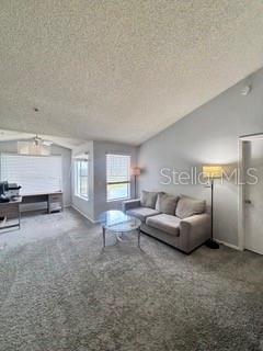 A living room features gray carpet, a light gray sofa, and a desk area — 2212 GRAND CAYMAN COURT UNIT 1637, KISSIMMEE, FL