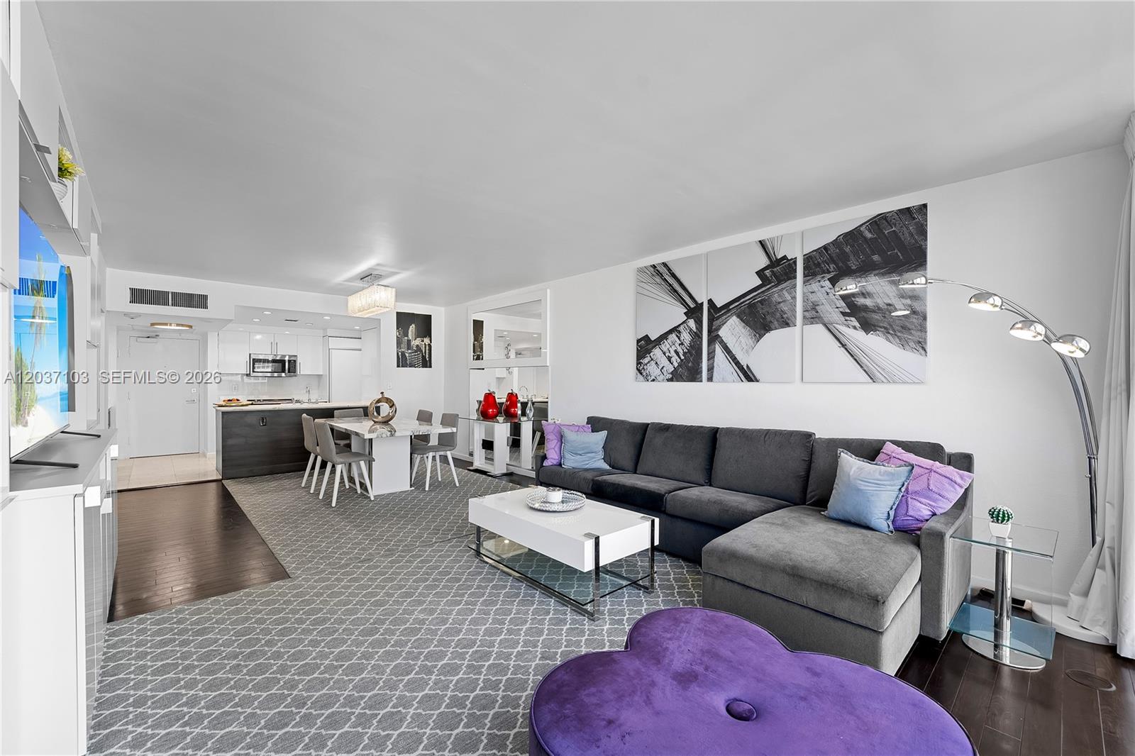 A living room and dining area feature a gray sectional, white coffee table, and carpet — 10275 Collins Ave # 807, Bal Harbour FL 33154, BAL HARBOUR, FL