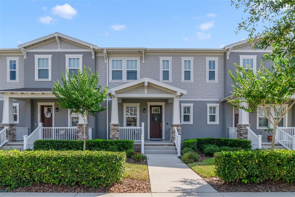 A two-story townhouse exterior features gray siding, stone accents, and a covered front porch — 2224 CELEBRATION BOULEVARD, CELEBRATION, FL
