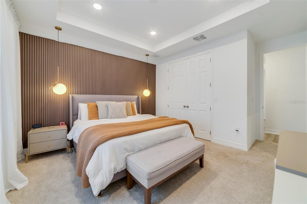 A bedroom features a bed with a textured brown accent wall and two pendant lights — 2224 CELEBRATION BOULEVARD, CELEBRATION, FL