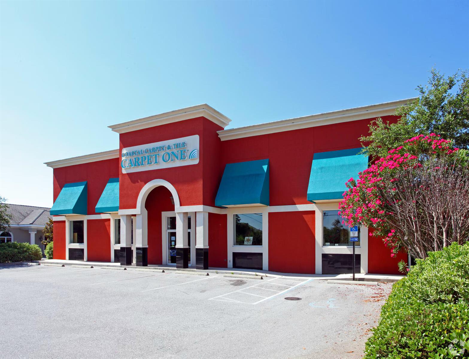 A red commercial building with teal awnings and a parking lot in front — 36070 Emerald Coast Parkway, FL 32541, FL