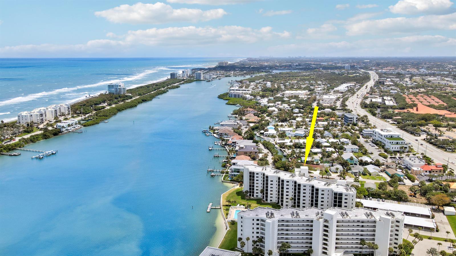 An aerial view shows a coastal neighborhood with a yellow arrow pointing toward a house — 19800 Sandpointe Bay Drive # 708, Tequesta FL 33469, TEQUESTA, FL