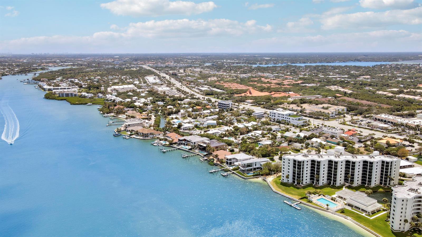 An aerial view shows a coastal neighborhood with waterfront homes and large apartment complexes — 19800 Sandpointe Bay Drive # 708, Tequesta FL 33469, TEQUESTA, FL