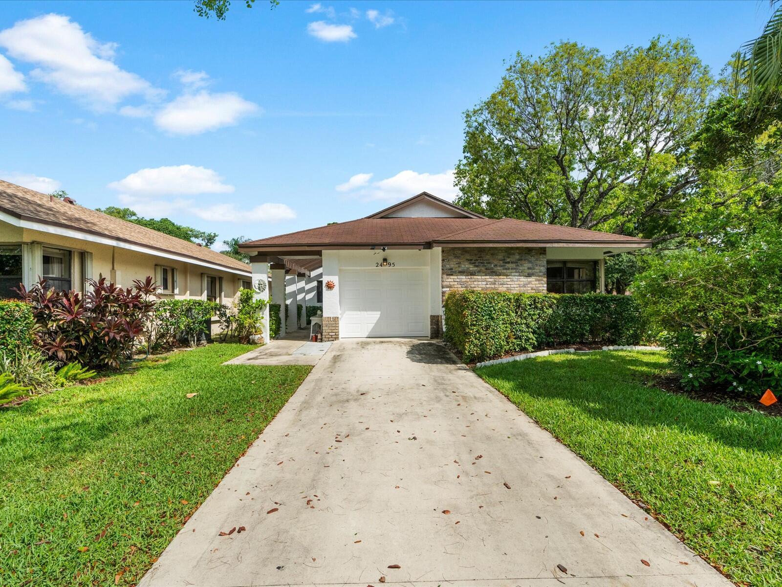 A single-story house with a white garage, brick facade, and a concrete driveway — 2495 Dawn Tree Terrace, Coconut Creek FL 33063, COCONUT CREEK, FL