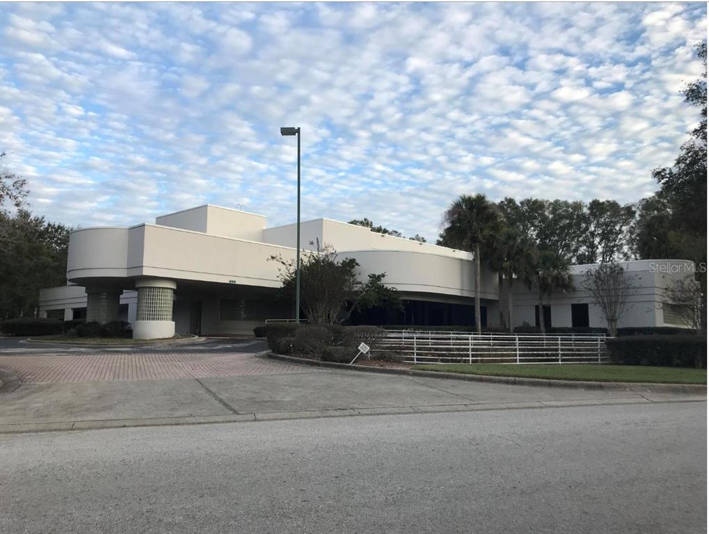 A low-rise commercial building with a curved facade and a covered entrance driveway — 3201 SW 34TH STREET FLOOR 2, OCALA, FL