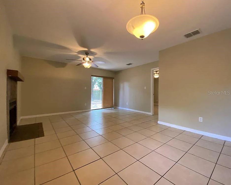 A living room with tan walls, light tile flooring, a fireplace, and a ceiling fan — 3254 HOWELL BRANCH ROAD, WINTER PARK, FL