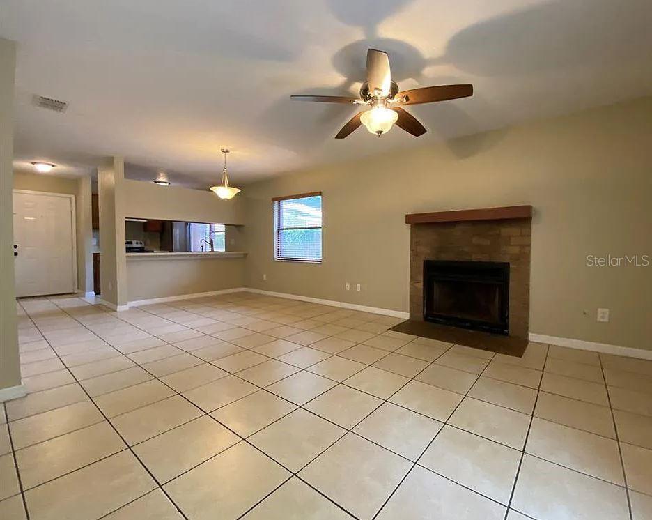 A living room with tile flooring, a brick fireplace, and a ceiling fan — 3254 HOWELL BRANCH ROAD, WINTER PARK, FL