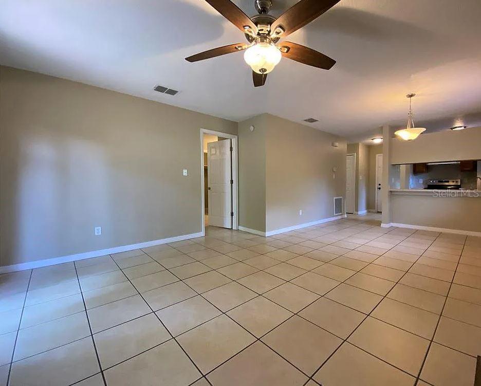 An open-concept living area features beige walls, tiled flooring, and a ceiling fan — 3254 HOWELL BRANCH ROAD, WINTER PARK, FL