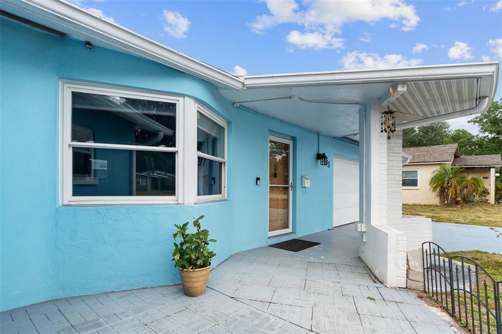 A bright blue house exterior features a covered porch, a bay window, and a garage — 4333 71ST AVENUE N, PINELLAS PARK, FL