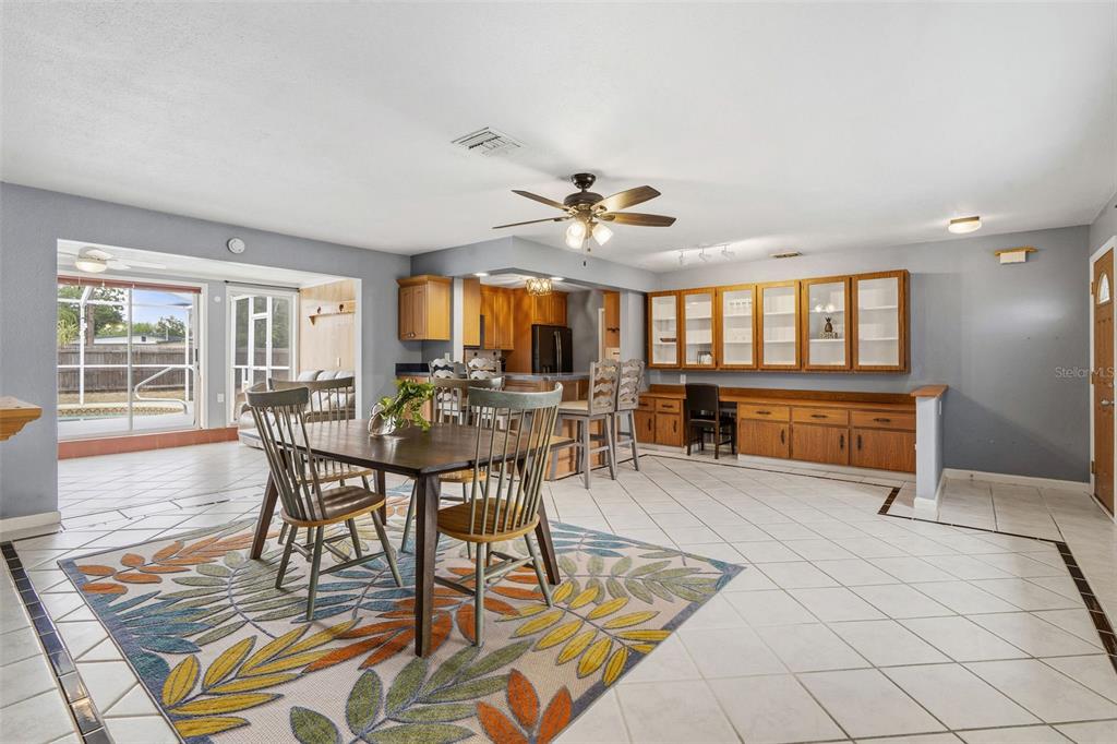 A dining area with a wooden table and chairs sits before a kitchen and cabinetry — 4333 71ST AVENUE N, PINELLAS PARK, FL