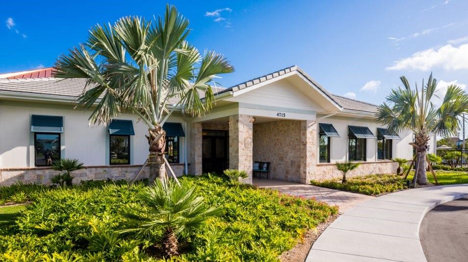 A single-story building with a stone-accented entrance, palm trees, and a paved walkway — 3917 AMERS LOOP, HAINES CITY, FL