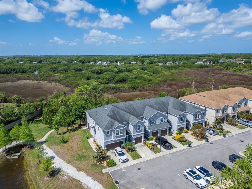 An aerial view shows a multi-unit townhouse building with gray siding and a dark roof — 8108 MUDDY PINES PLACE UNIT 8108, TAMPA, FL