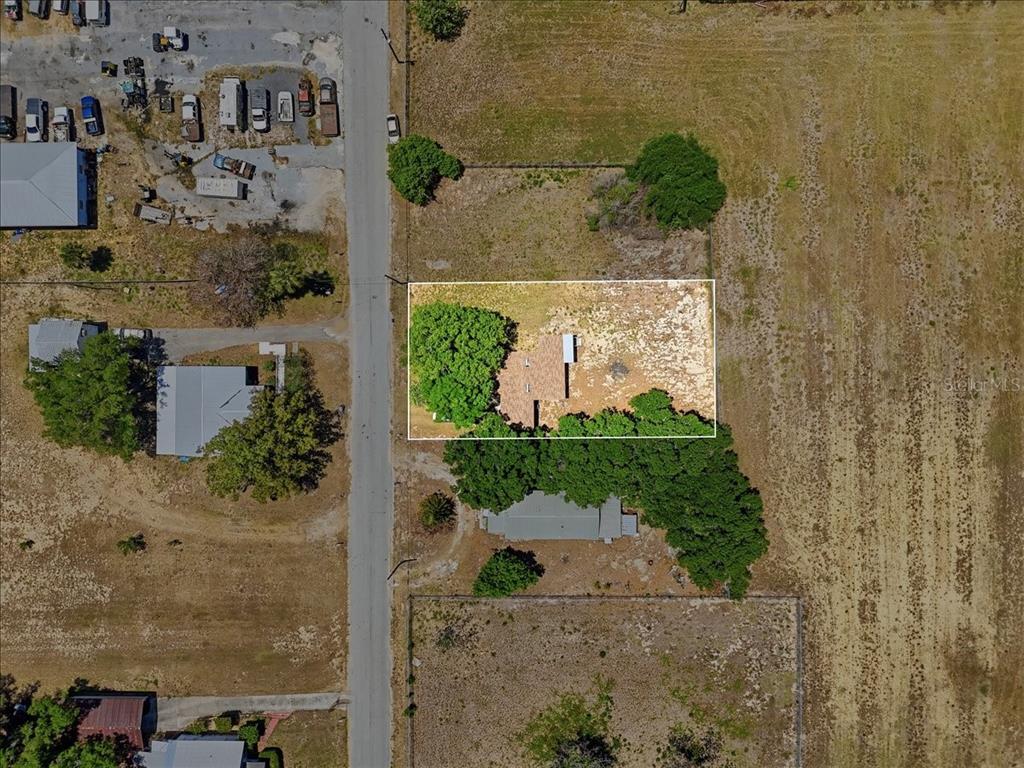 An aerial view shows a house with a white outline on a rural lot — 13 E 8TH STREET, FROSTPROOF, FL