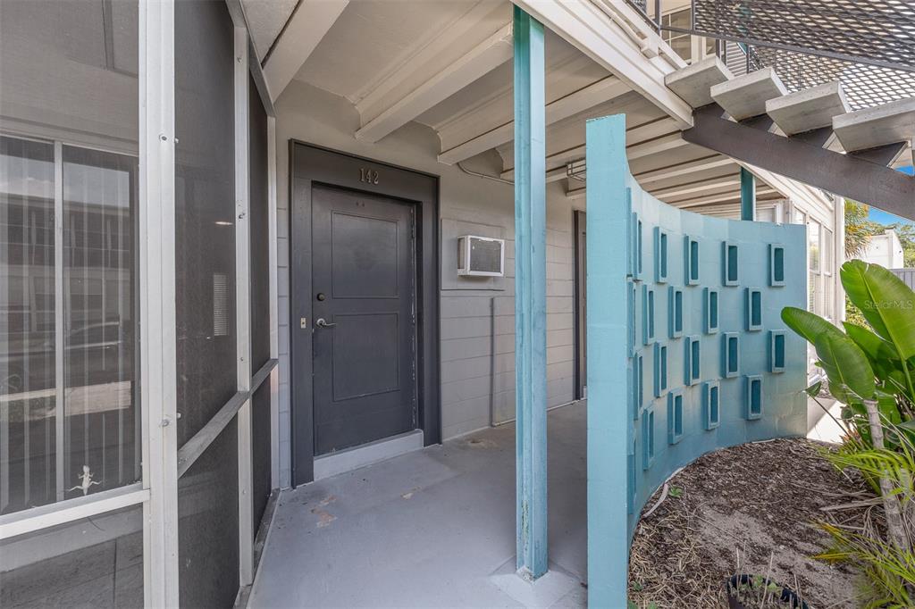 An exterior view of a residential unit entrance with a dark door and blue screen — 151 NORTH ORLANDO AVENUE UNIT 142, WINTER PARK, FL
