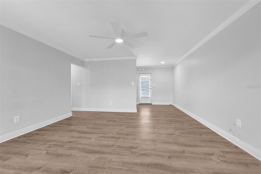 An empty living room features light gray walls, wood-look flooring, and a white ceiling fan — 151 NORTH ORLANDO AVENUE UNIT 142, WINTER PARK, FL