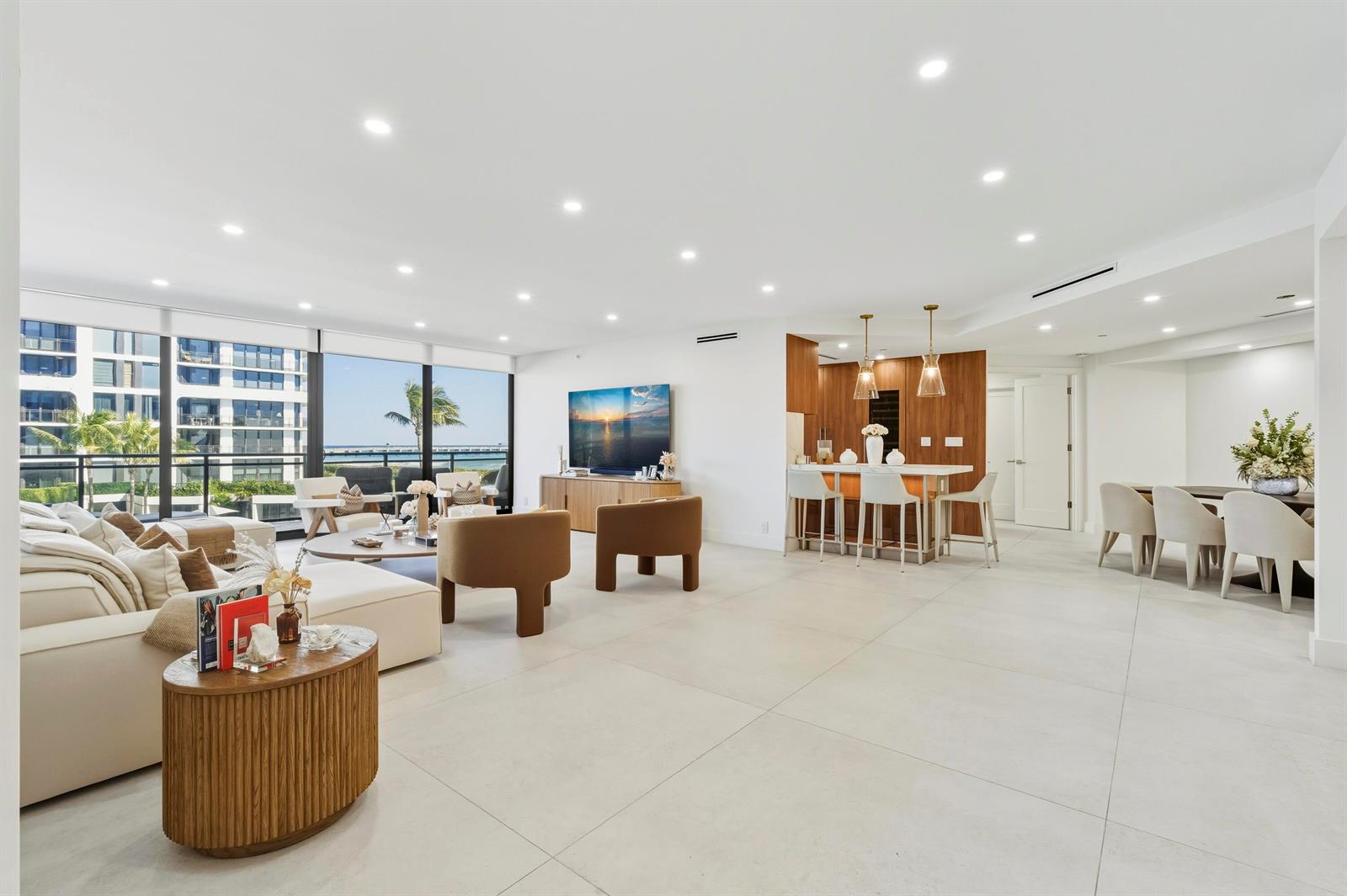 A modern open-concept living area features a kitchen island, dining space, and oceanfront balcony views — 3100 S Ocean Boulevard # 201s, Palm Beach FL 33480, PALM BEACH, FL