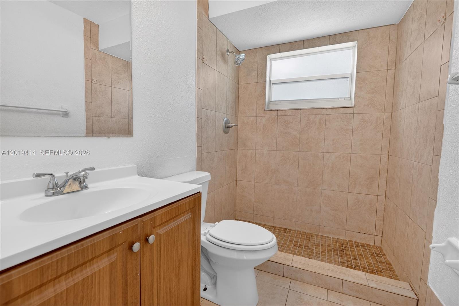 A bathroom features a wood vanity, a white toilet, and a tiled walk-in shower — 20841 SW 103rd Ct, Cutler Bay FL 33189, CUTLER BAY, FL