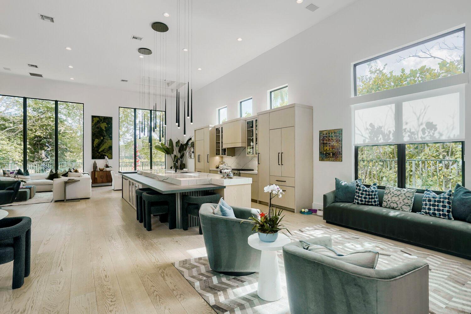 A modern open-concept kitchen and living area with high ceilings, large windows, and neutral finishes — 6179 Vía Venetia S, Delray Beach FL 33484, DELRAY BEACH, FL
