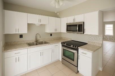 A kitchen with white cabinets, stainless steel appliances, and light-colored countertops — 3011 ERNEST DRIVE, AUBURNDALE, FL