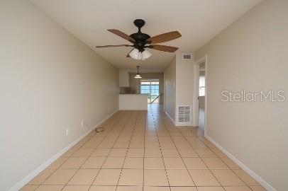 A long room with light-colored tile flooring, a ceiling fan, and a view of the kitchen — 3011 ERNEST DRIVE, AUBURNDALE, FL