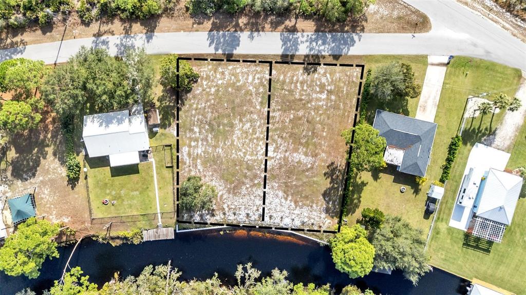 An aerial view shows two adjacent vacant waterfront lots outlined in black — 1102 SYCAMORE STREET, LAKE PLACID, FL