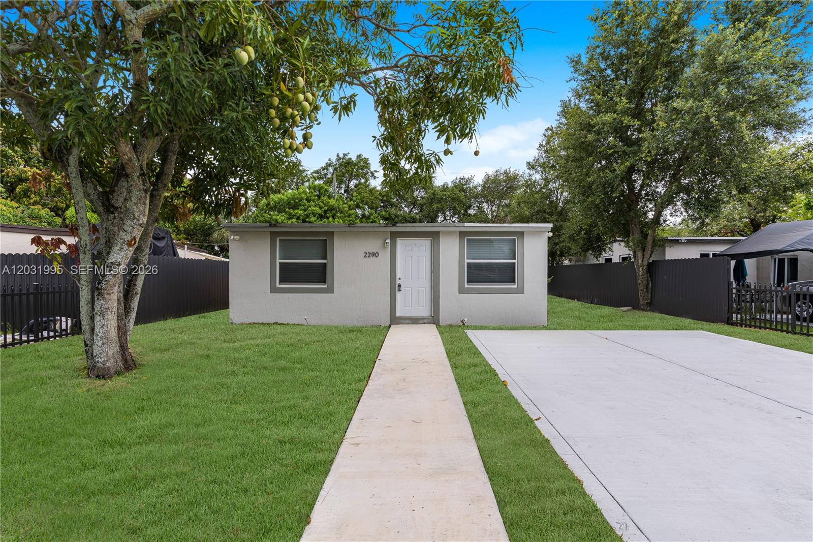 A single-story house with a white door, two windows, and a concrete driveway — 2290 Rutland St, Opa-Locka FL 33054, OPA-LOCKA, FL