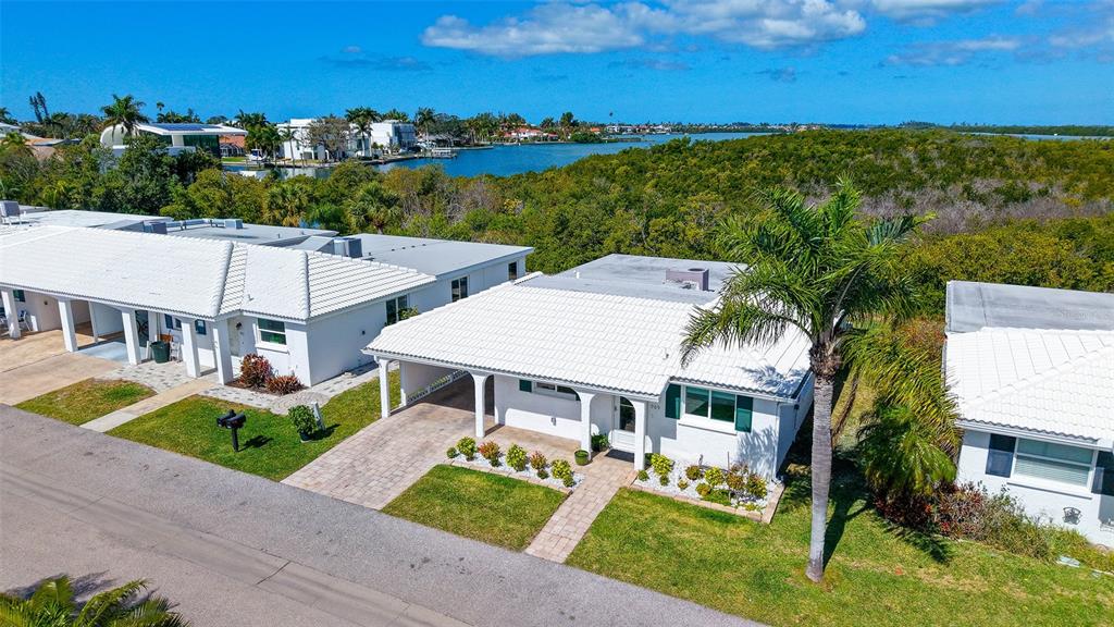 An aerial view of white-roofed villas with carports and palm trees near a waterway — 909 SPANISH DRIVE N, LONGBOAT KEY, FL