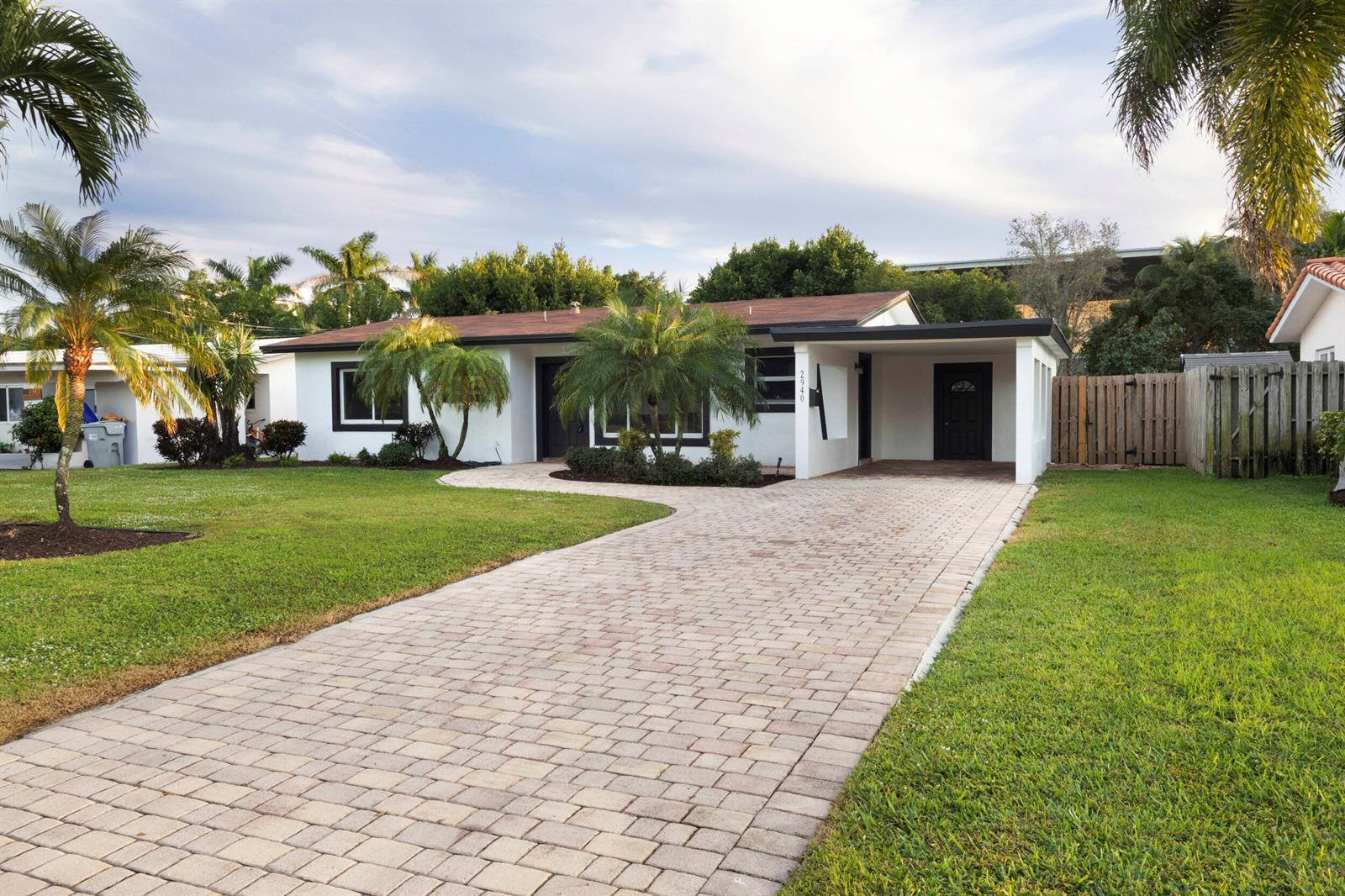 A single-story white house with a brown roof, a paved driveway, and palm trees — 2940 NE 18th Street, Pompano Beach FL 33062, POMPANO BEACH, FL
