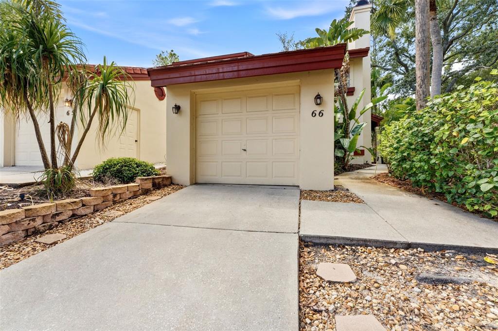 A beige garage with a red trim roof and the number 66 on the wall — 3460 COUNTRYSIDE BOULEVARD UNIT 66, CLEARWATER, FL