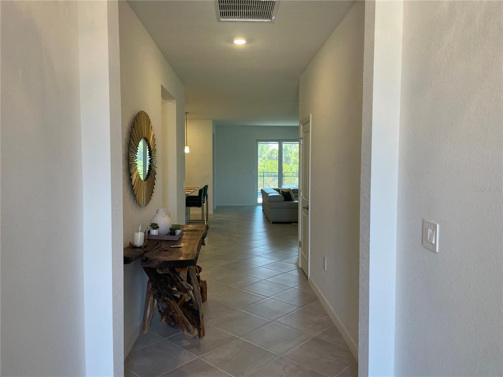 A tiled entryway leads into an open-concept living area with a rustic wood console table — 11308 PINOT DRIVE, VENICE, FL