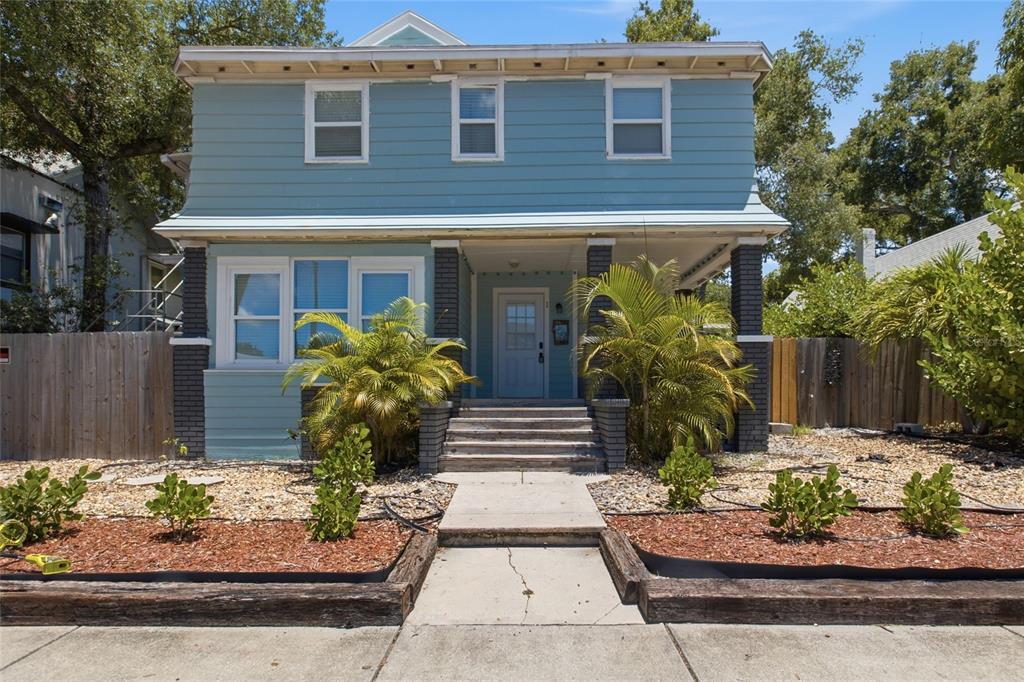 A two-story blue house with a front porch, brick pillars, and a concrete walkway — 335 5TH AVENUE N, ST PETERSBURG, FL