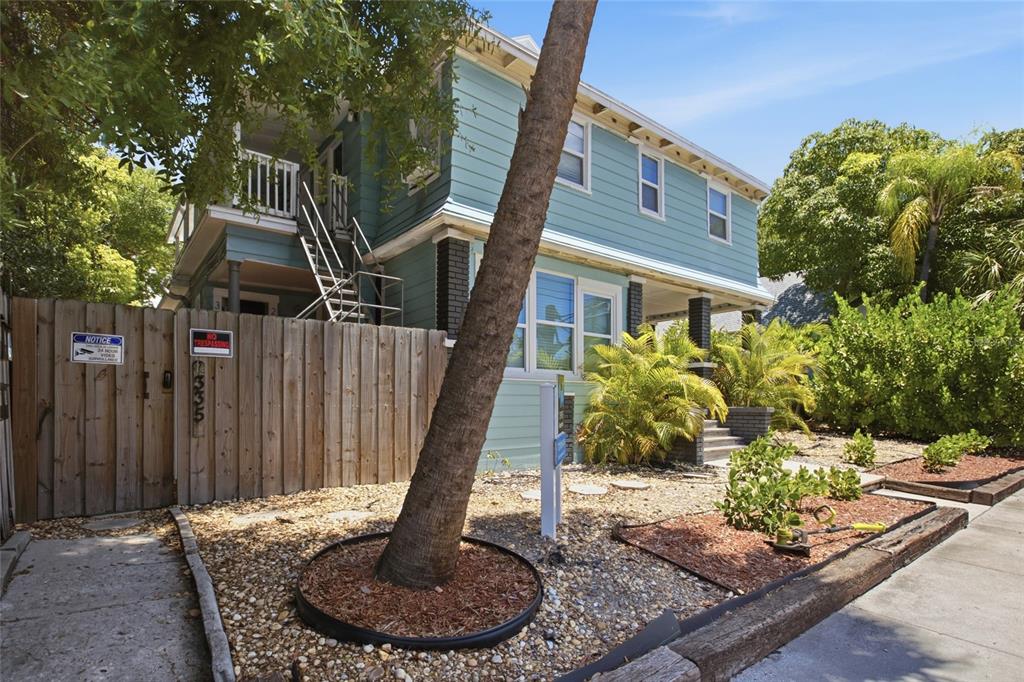 A two-story light blue house with a wooden fence and a palm tree in front — 335 5TH AVENUE N, ST PETERSBURG, FL