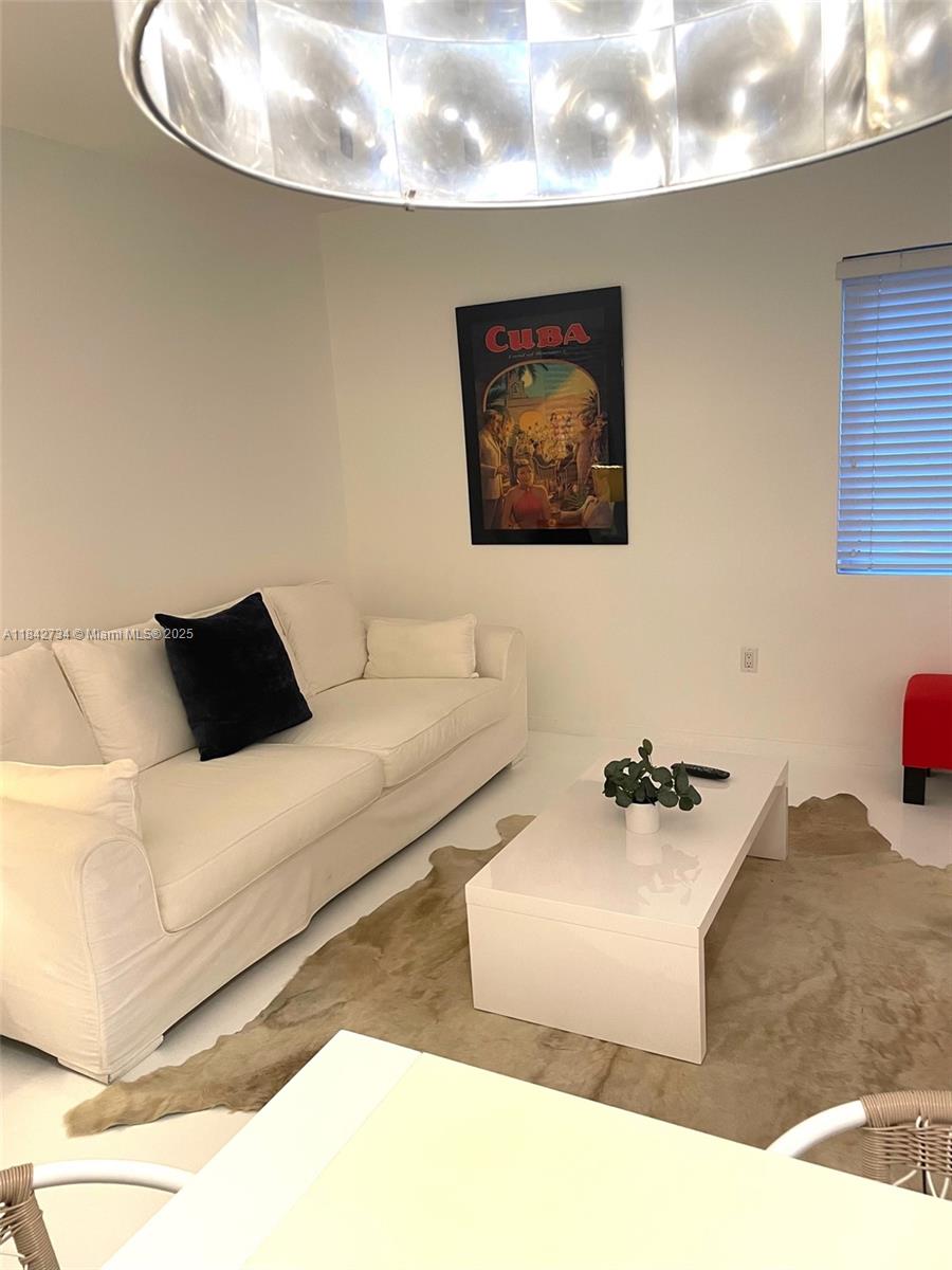 A living room features a white sofa, a coffee table on a rug, and wall art — 1616 Euclid Ave # 14, Miami Beach FL 33139, MIAMI BEACH, FL
