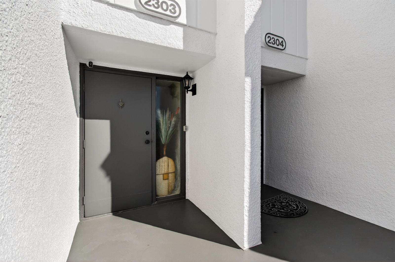 Two adjacent residential entryways with white stucco walls and dark gray doors — 2303 Bridgewood Drive # 2303, Boca Raton FL 33434, BOCA RATON, FL