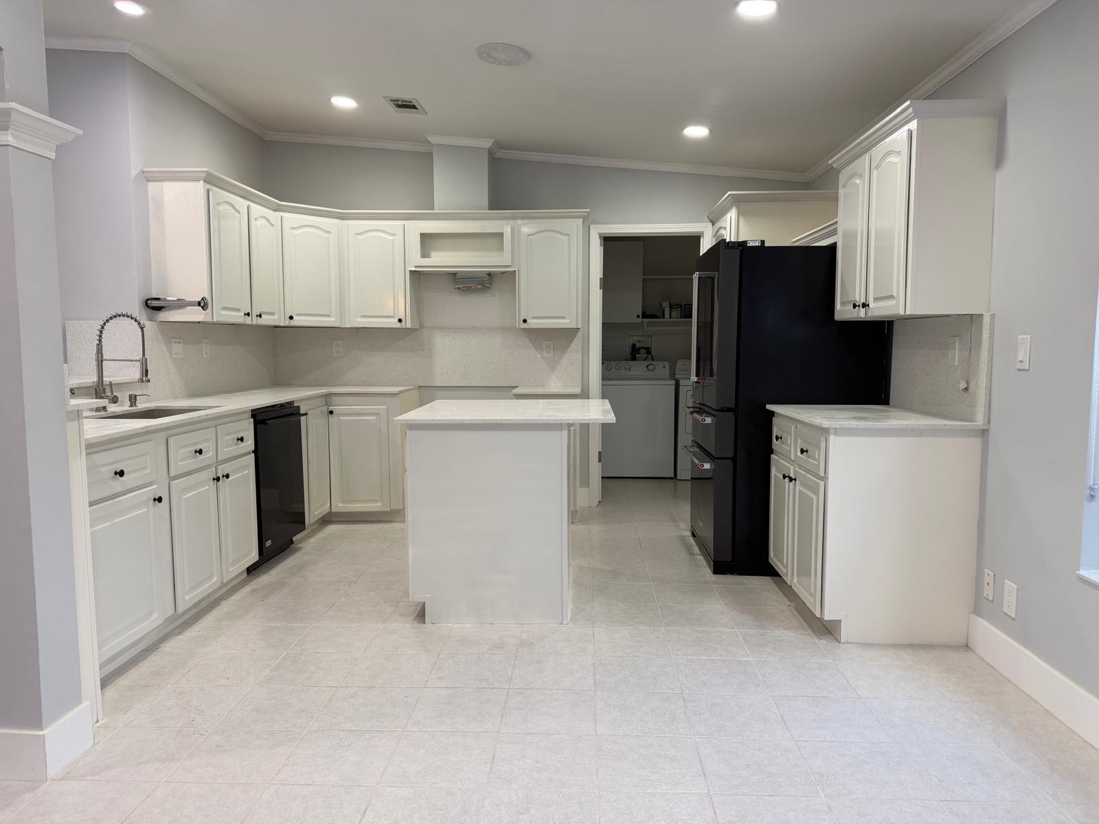 A kitchen with white cabinets, light countertops, black appliances, and a central island — 4165 3rd Court, Atlantis FL 33462, ATLANTIS, FL