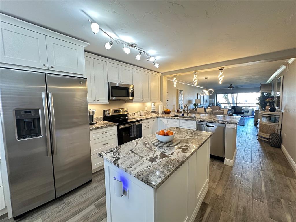 A kitchen with white cabinets, granite countertops, stainless steel appliances, and a central island — 106 1ST STREET E UNIT 115, ST PETERSBURG, FL
