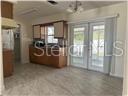A kitchen with wood cabinets and tile flooring features glass doors leading to the outdoors — 1017 E 1ST AVENUE, MOUNT DORA, FL