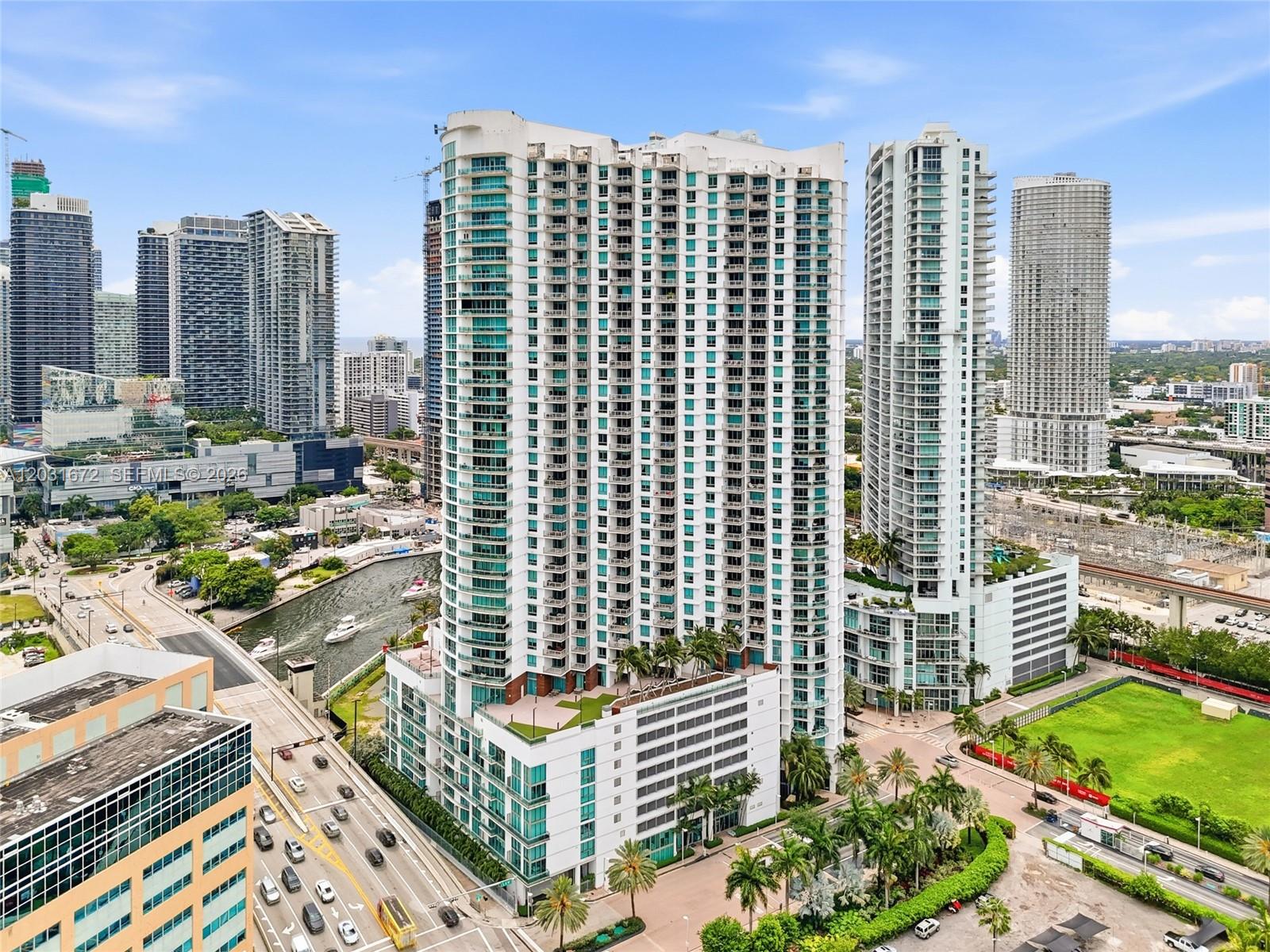 An aerial view of a tall residential skyscraper in a dense urban city setting — 350 S Miami Ave # 3912, Miami FL 33130, MIAMI, FL