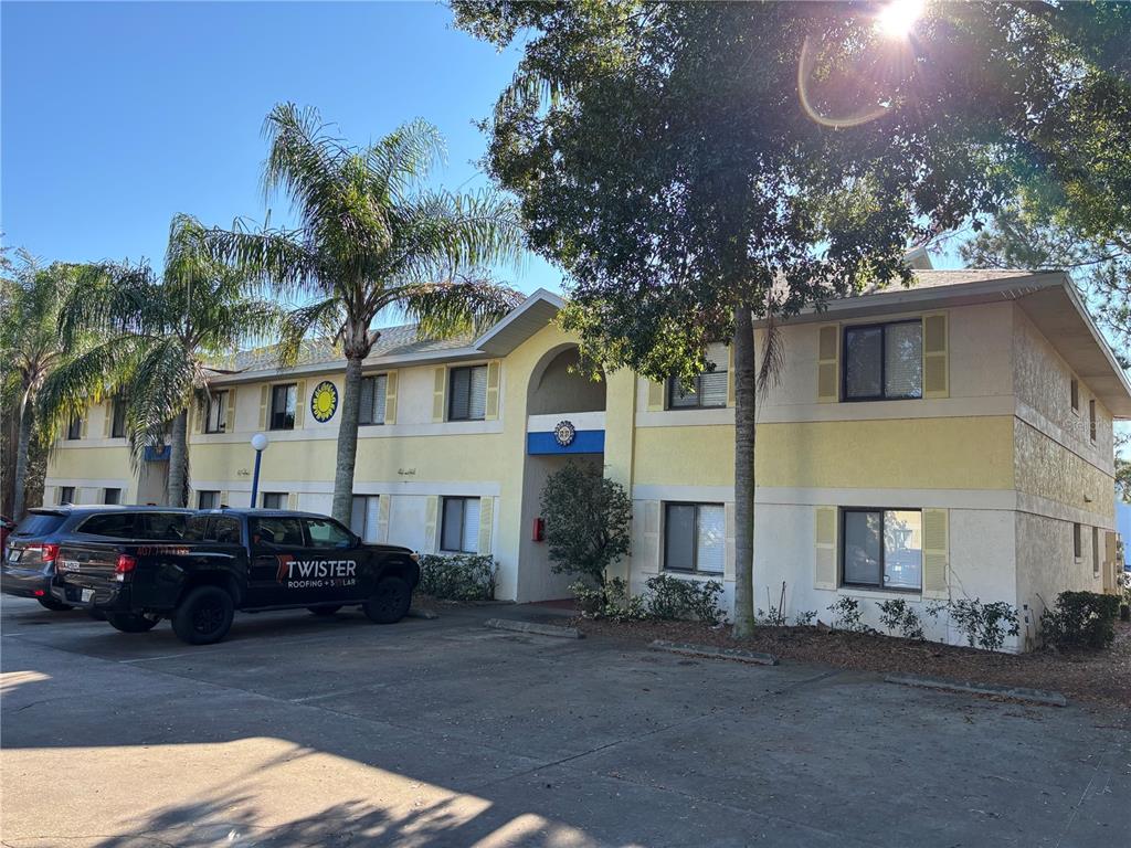 A two-story apartment building with yellow stucco walls and a dark truck parked outside — 90 HIDDEN LAKE DRIVE UNIT 178, SANFORD, FL