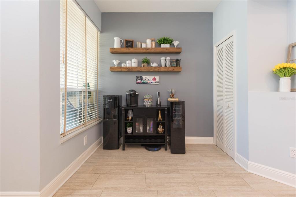 A dining area features a coffee bar, floating shelves, and a window with blinds — 1050 STARKEY ROAD UNIT 104, LARGO, FL