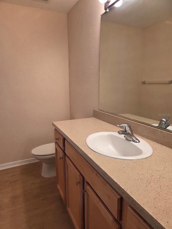 A bathroom features a light-colored vanity with a single sink, wood cabinets, and a toilet — 5824 LAKE POINTE VILLAGE CIRCLE UNIT 504, ORLANDO, FL