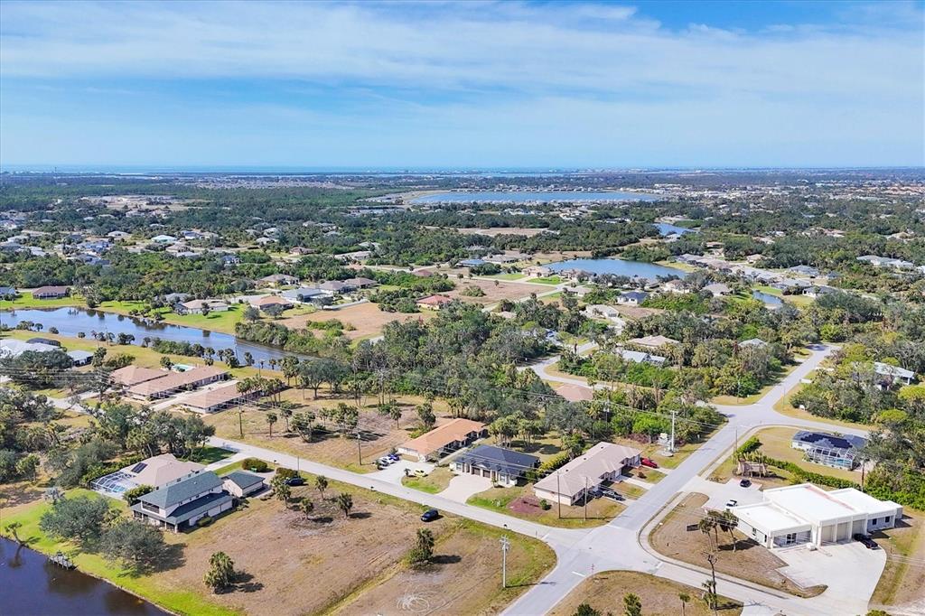 An aerial view shows a suburban neighborhood with houses, roads, and several small lakes — 355 BOUNDARY BOULEVARD UNIT C, ROTONDA WEST, FL