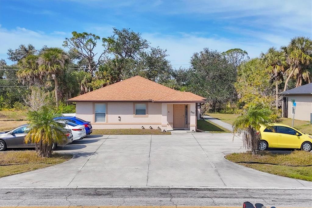 A single-story house with a tan exterior, hip roof, and a large concrete driveway — 355 BOUNDARY BOULEVARD UNIT C, ROTONDA WEST, FL