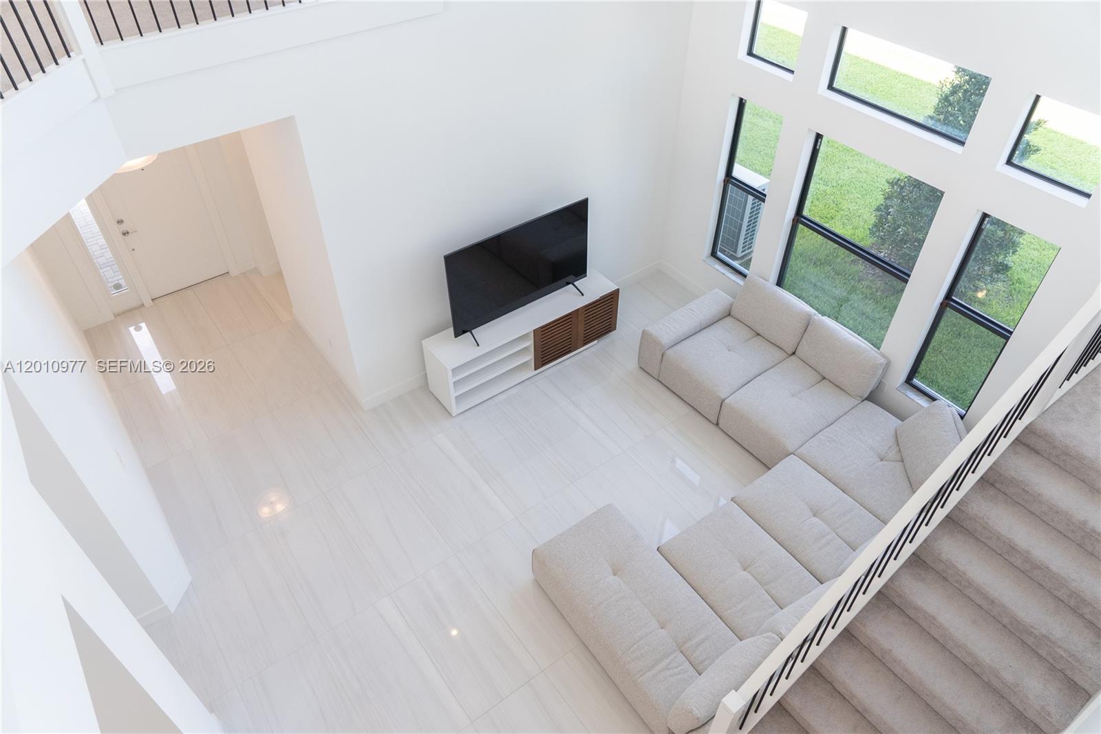 A high-angle view shows a living room with white tile floors, a sectional sofa, and tall windows — 8151 Laurel Falls Dr, Boca Raton FL 33496, BOCA RATON, FL