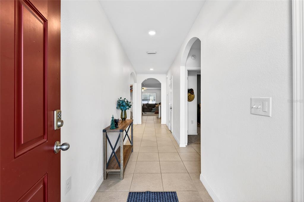 A tiled entryway leads through an arched hallway into a living area with white walls — 2530 NE 42ND ROAD, OCALA, FL