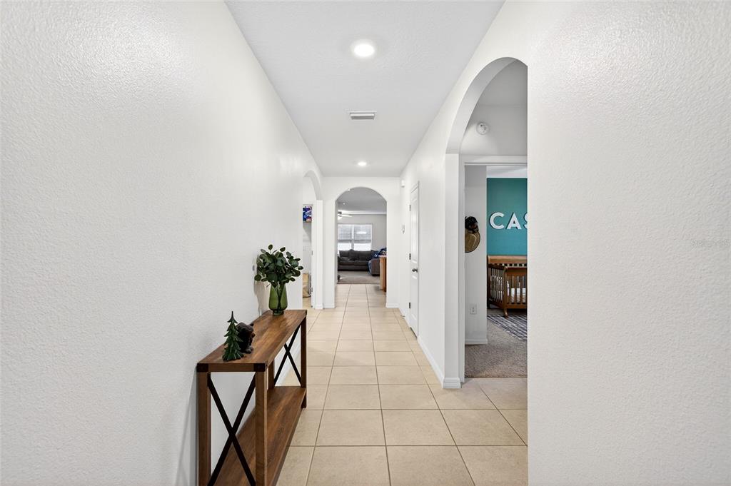 A tiled hallway leads through arched doorways toward a living area and a bedroom — 2530 NE 42ND ROAD, OCALA, FL