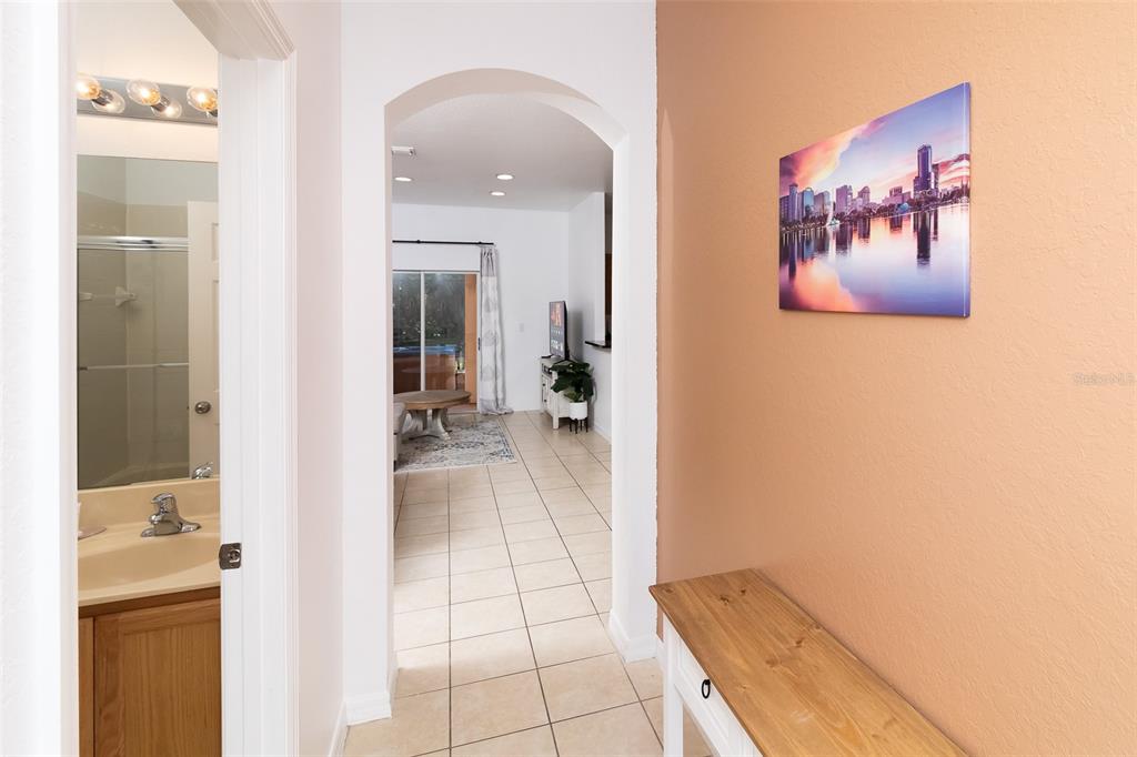 A hallway with a bathroom on the left leads to a living area with tile floors — 2771 CORVETTE LANE, KISSIMMEE, FL