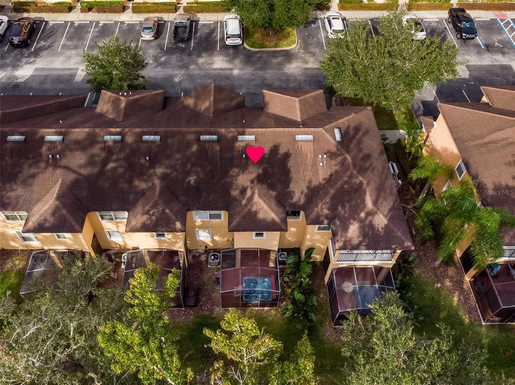 An aerial view shows the brown shingled roof of a multi-unit townhouse with a hot tub — 2771 CORVETTE LANE, KISSIMMEE, FL
